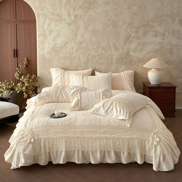 Luxury bedding set with quilted coverlet, lace ruffle, and decorative bed skirt