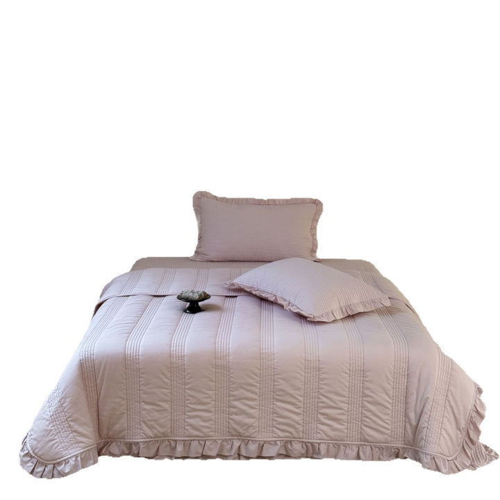 Padded quilted bedding set with ruffled trim and fine channel stitching