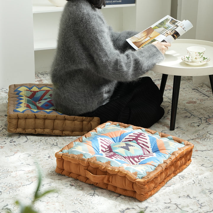 Square seat cushion with kilim-inspired pattern, quilted padding and carrying handle