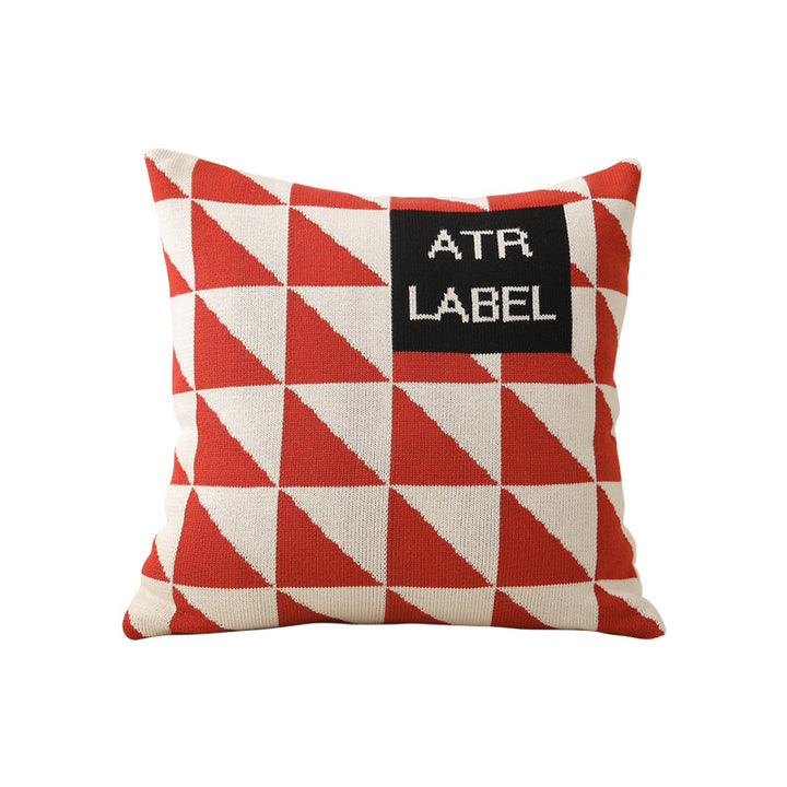 Geometric knit pillow with triangle pattern and logo patch