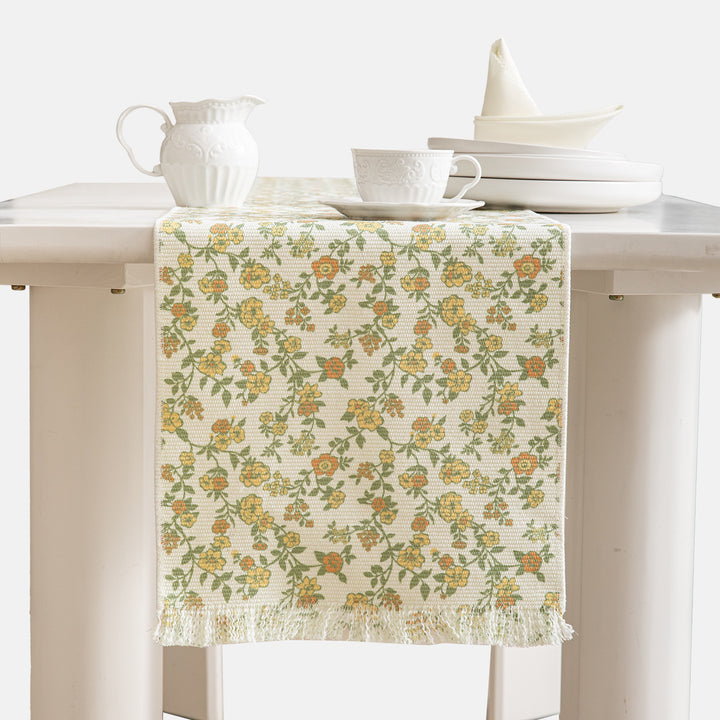 Woven table runner with flower jacquard, fringes and cotton blend