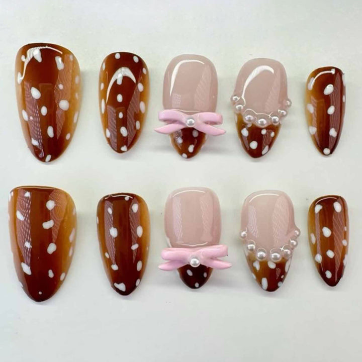 Artificial nail art with dot pattern and bow accents Stornfield