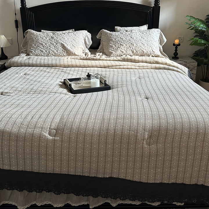 Quilted bedspread with lace trim and vintage stripe pattern