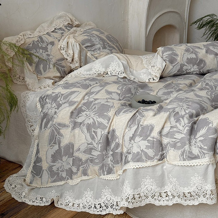 Vintage-inspired cotton-linen bedding set with large floral pattern, ruffle, and lace appliqué