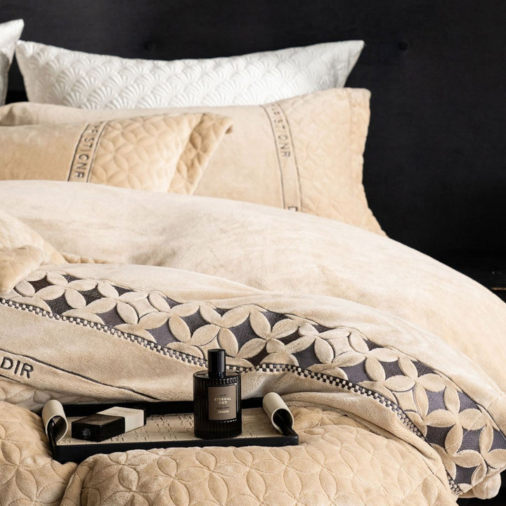 Quilted bedding set with geometric quilting and decorative ribbon