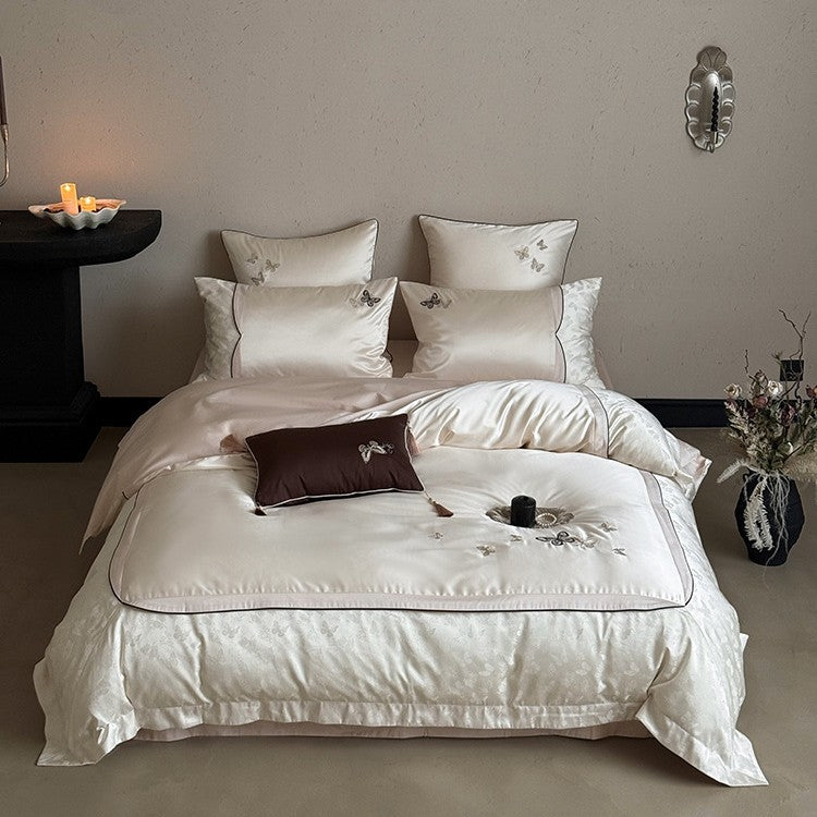 Luxurious satin bedding set with embroidered butterflies, decorative pillows, and tassels