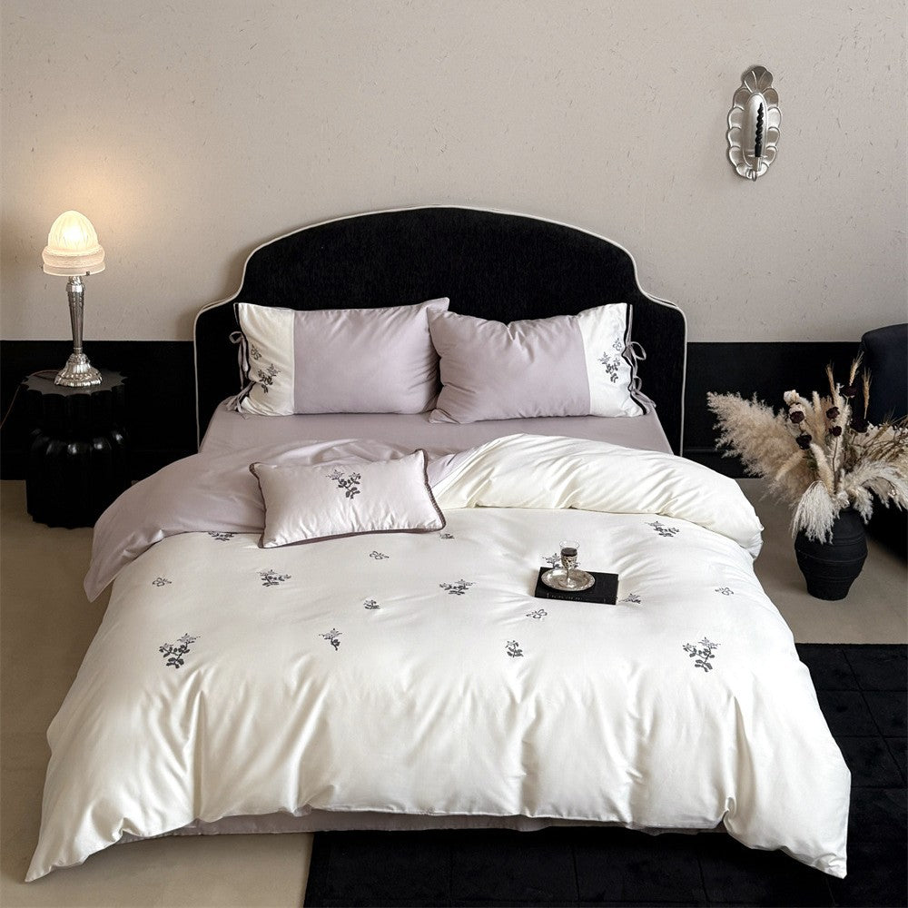 Luxurious satin bedding set with embroidered flower pattern and decorative pillow