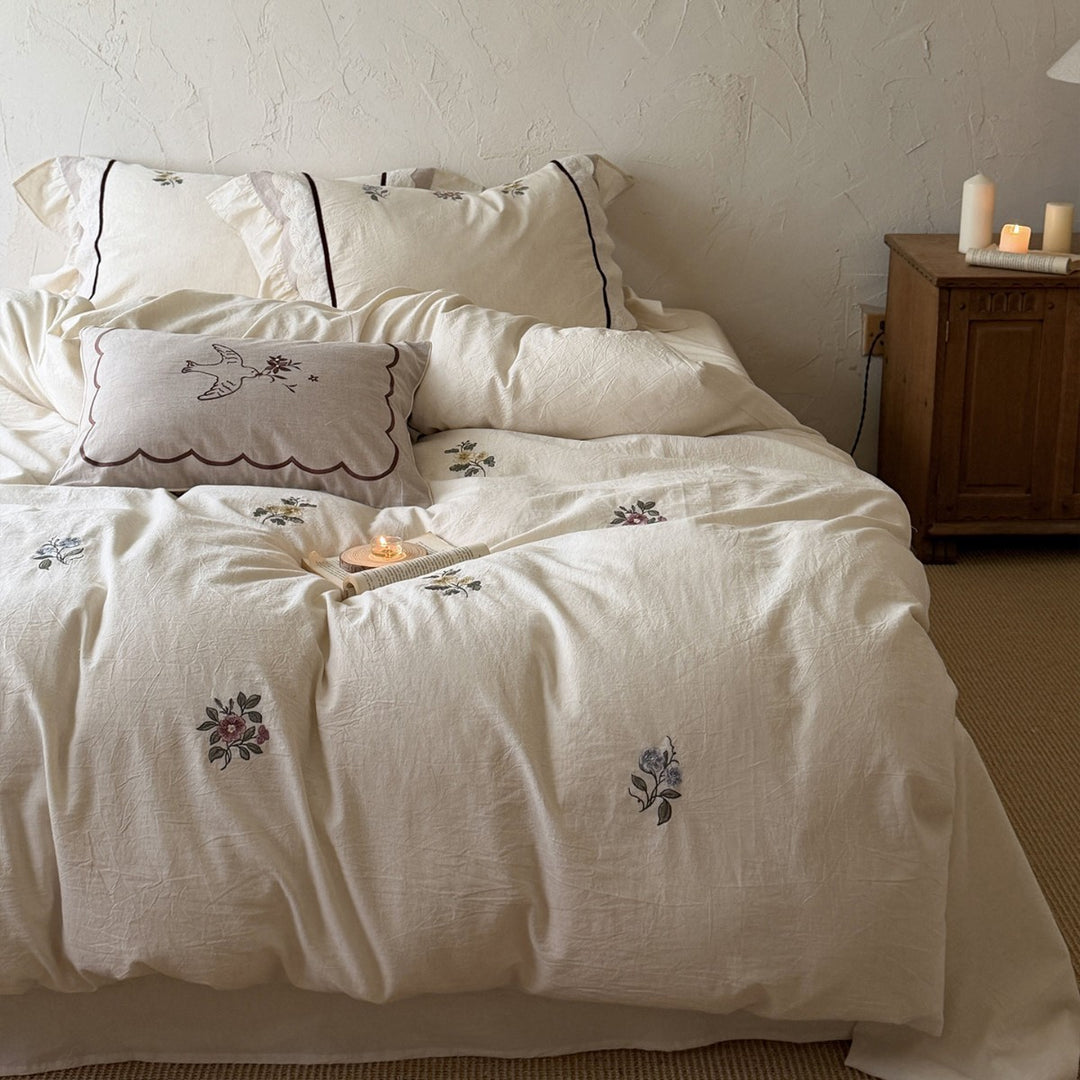 Romantic linen-cotton bedding set with delicate floral embroidery, tie loops and round cushion