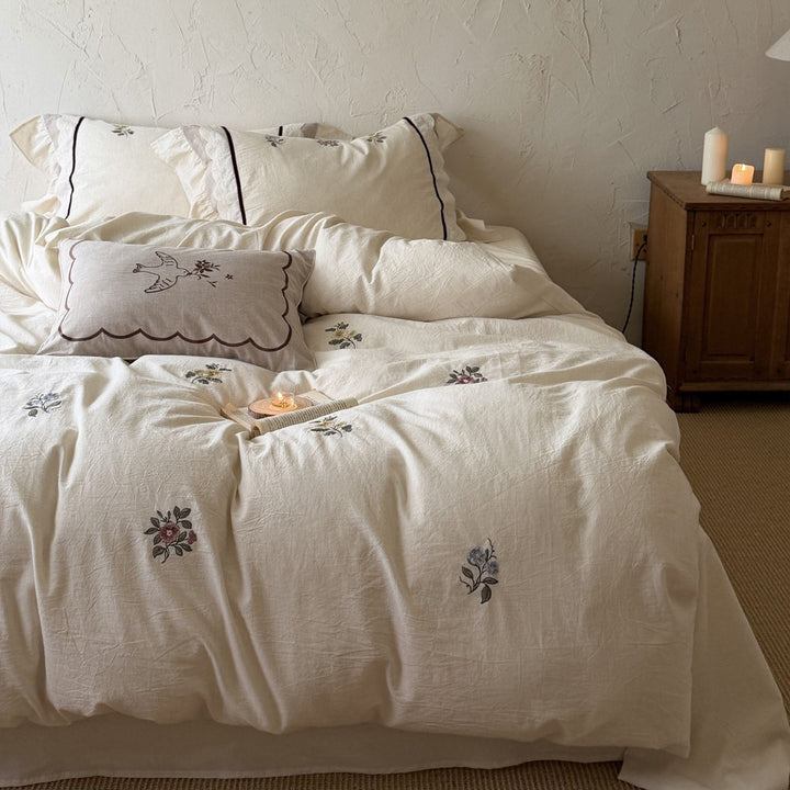 Romantic linen-cotton bedding set with delicate floral embroidery, tie loops and round cushion