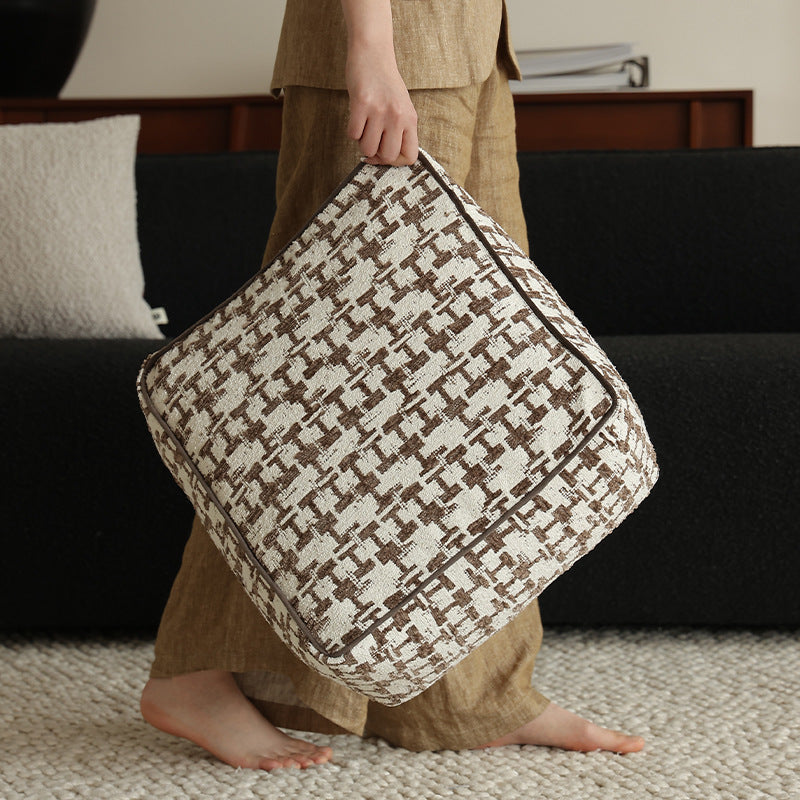 Square floor pouf with houndstooth jacquard, piping seam, and shape-stable foam core