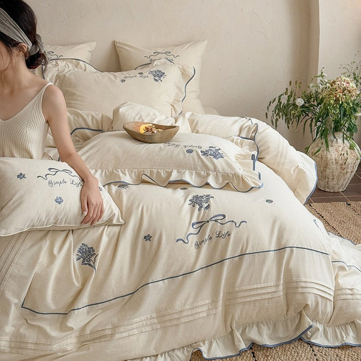 Cotton muslin bedding set with delicate floral embroidery, ruffle, and breathable finish