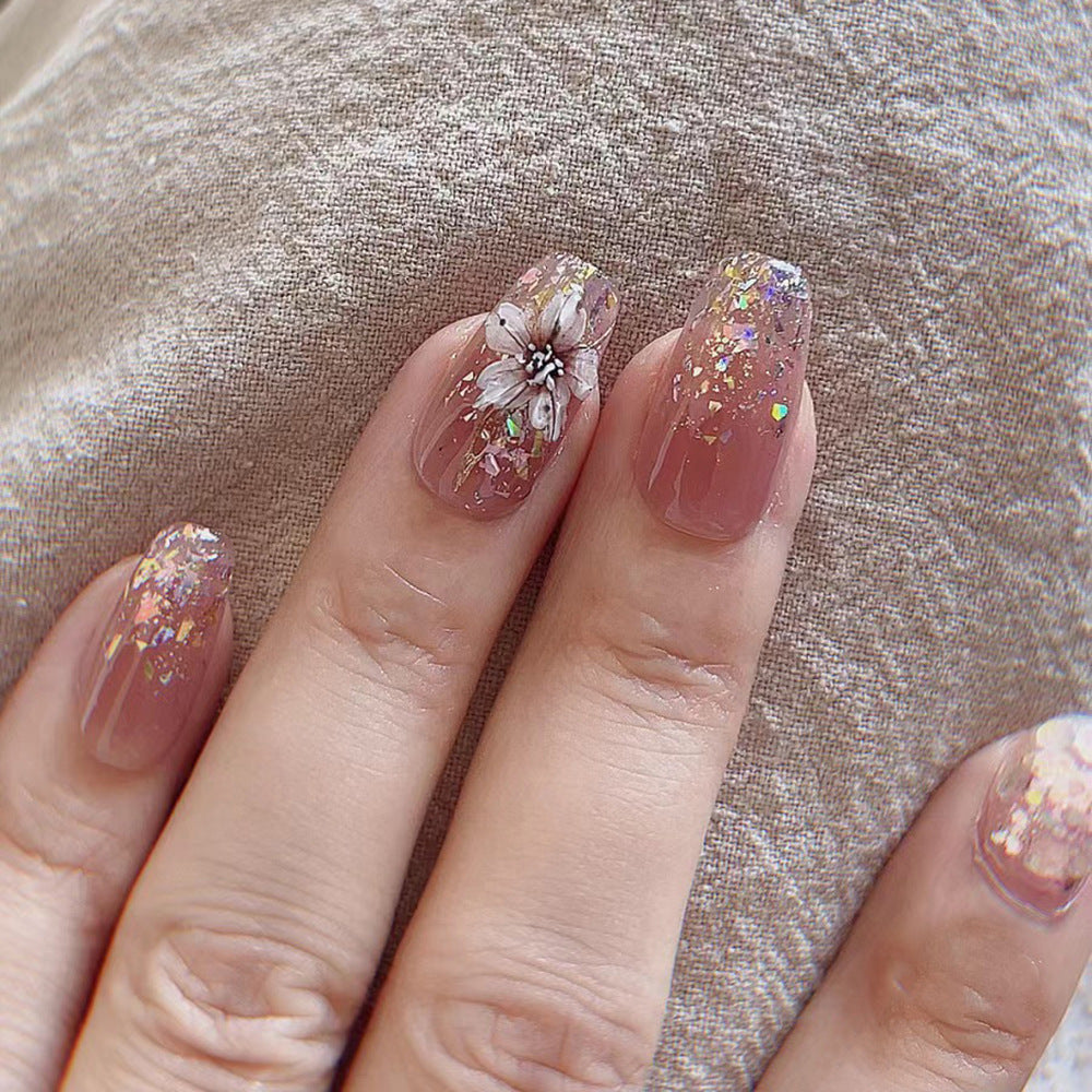Artificial nail extensions with floral design and glitter accents Stornfield