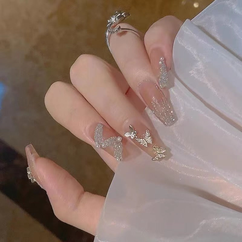 Glamorous nail art with rhinestone and butterfly elements Stornfield