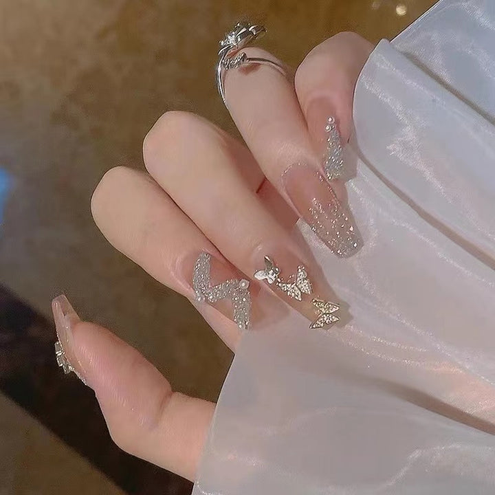Glamorous nail art with rhinestone and butterfly elements Stornfield