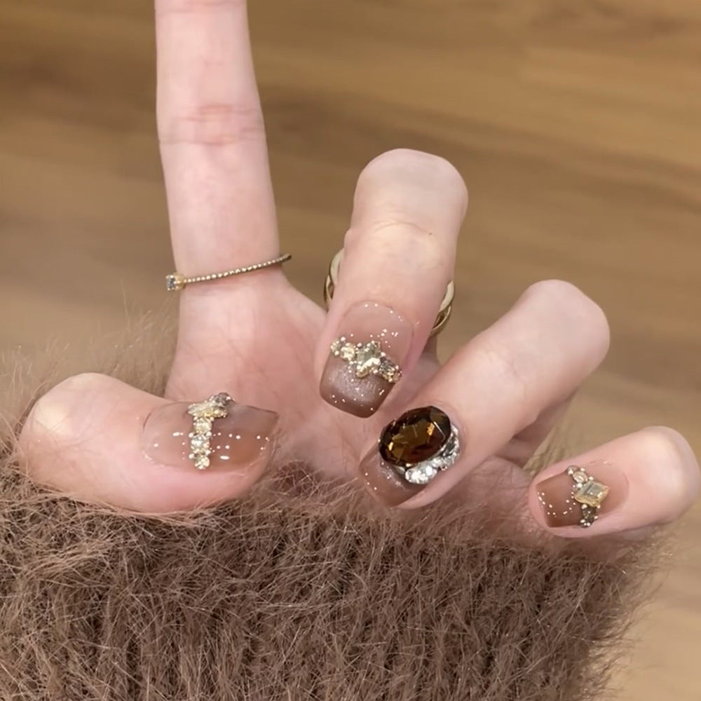 Artificial nail art with glitter and jewelry embellishments Stornfield