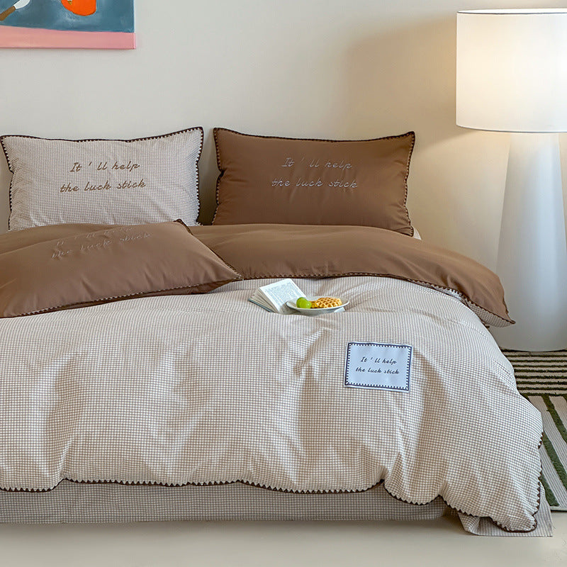 Striped cotton bedding set with subtle slogan appliqués and decorative piping