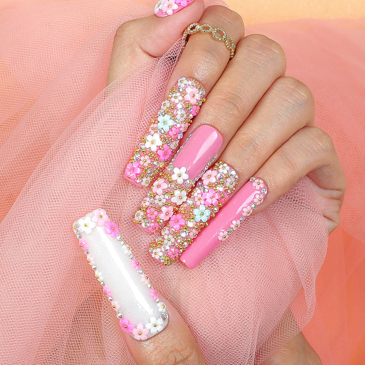 Artificial nail set with floral decorations and glitter accents Stornfield