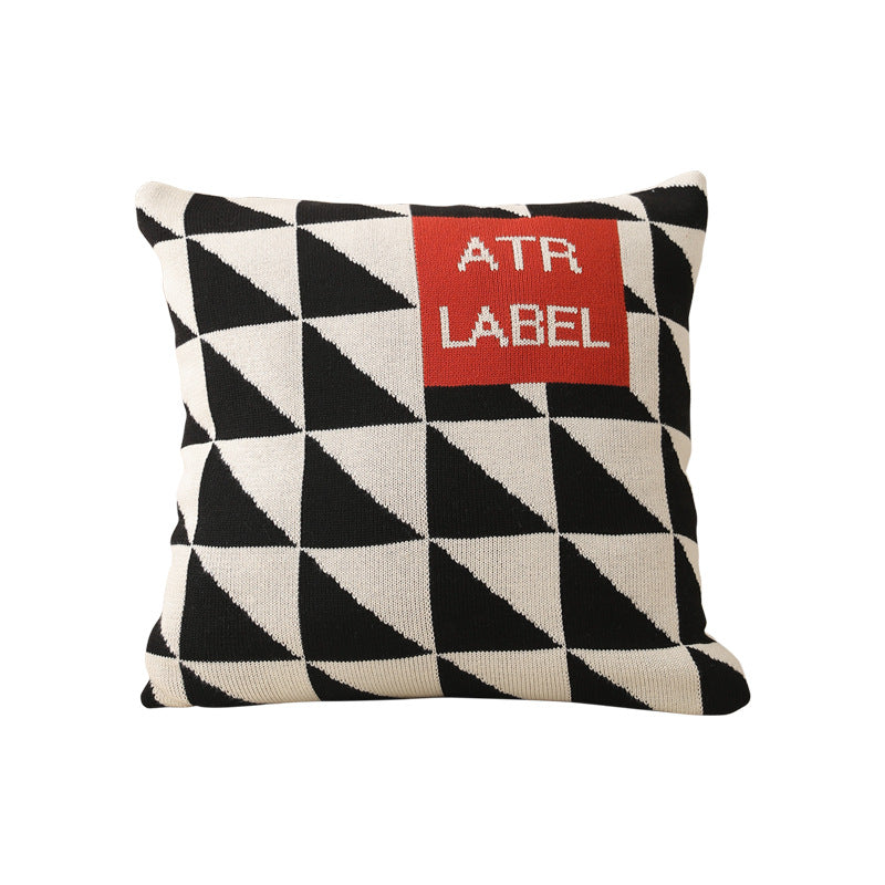 Geometric knit pillow with triangle pattern and logo patch