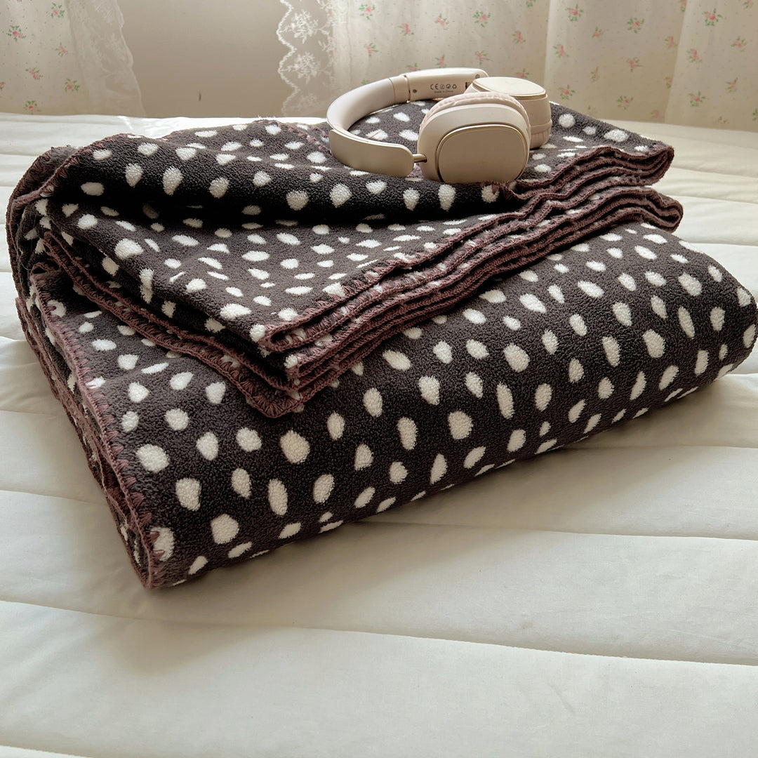 Microfleece cuddly blanket with polka dot pattern and decorative overlock seam