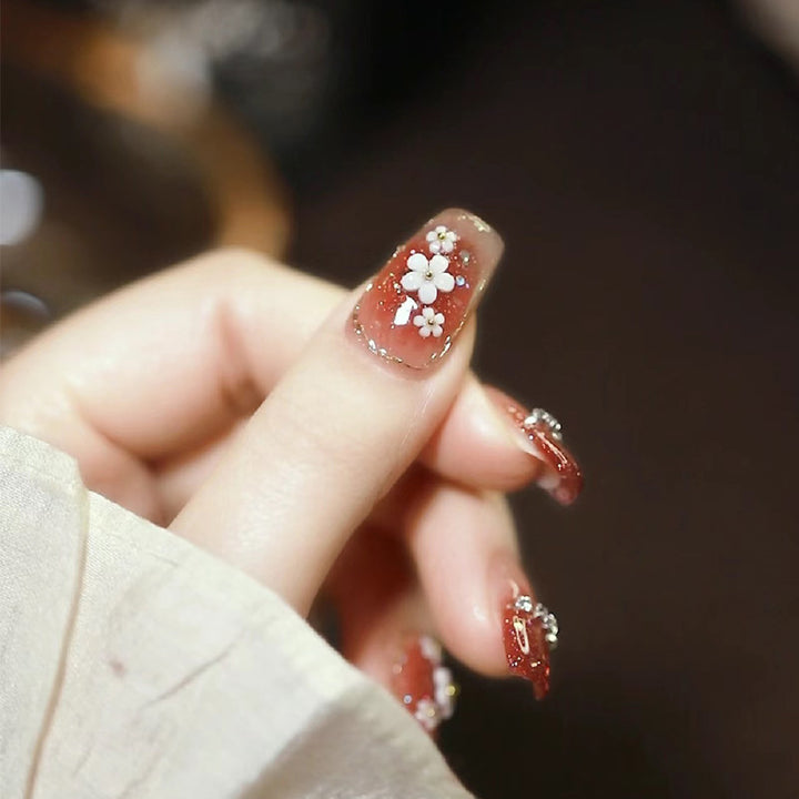 Artistic Press-On Nail Art with Floral and Glitter Accents Stornfield