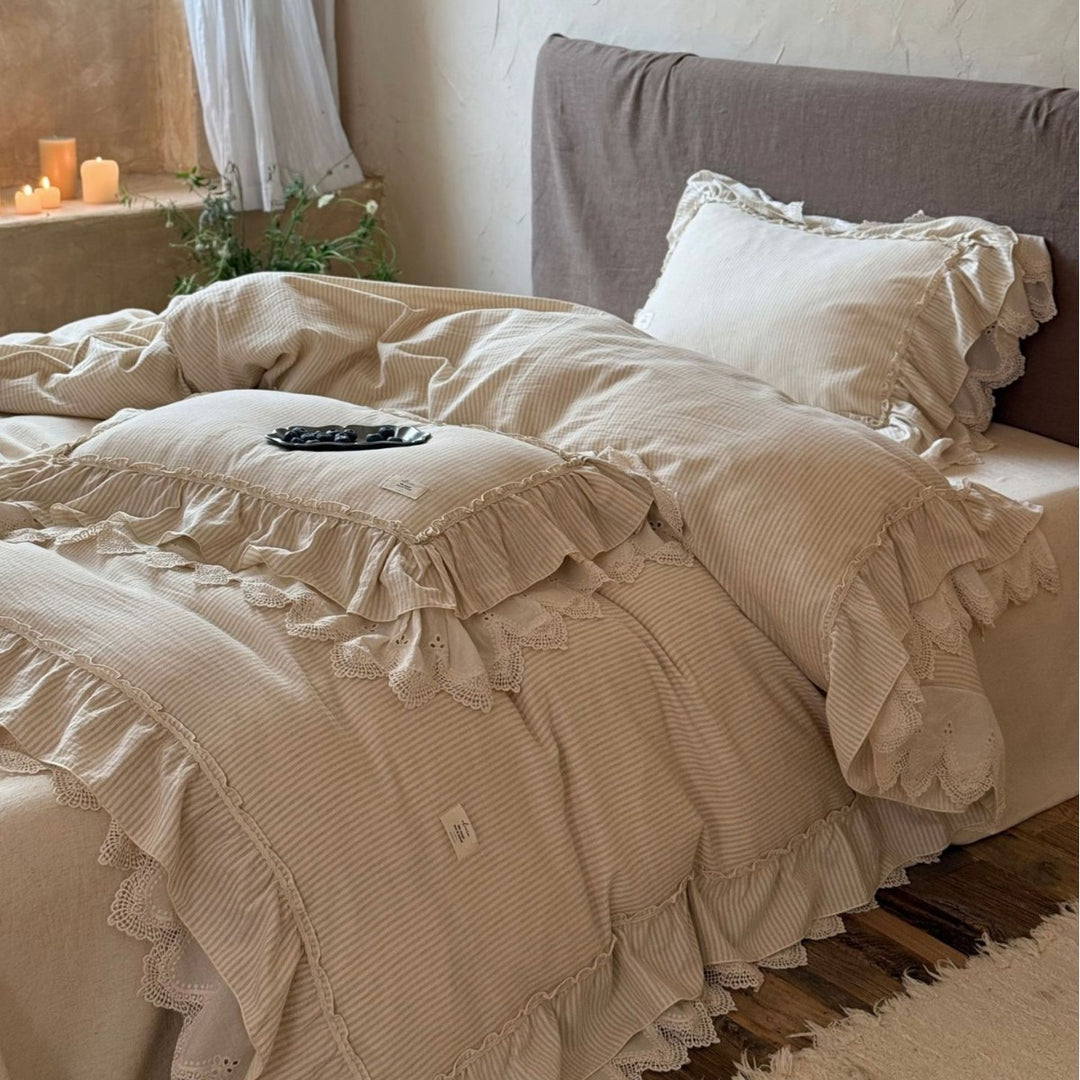 Country house style bed linen set with ruffles, lace border and quilted bedspread