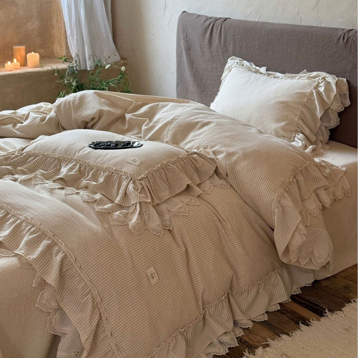 Country house style bed linen set with ruffles, lace border and quilted bedspread