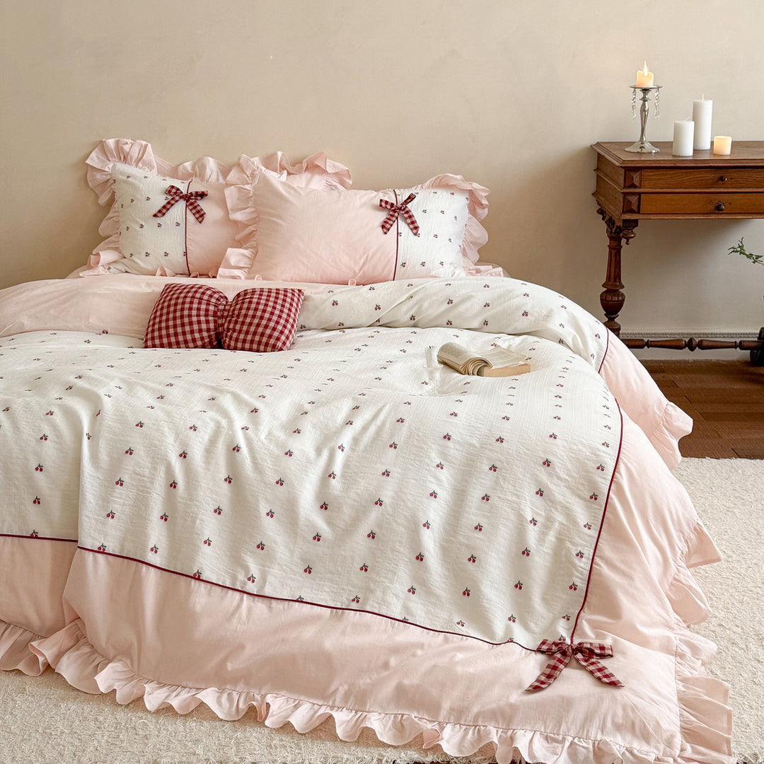 Playful ruffled bed set made of cotton muslin with embroidered cherries and checkered bows