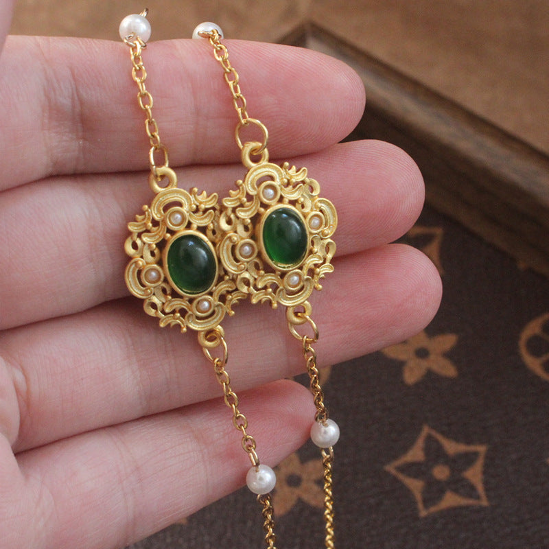 Elegant jewelry display chain with pearls and green stone decoration Stornfield