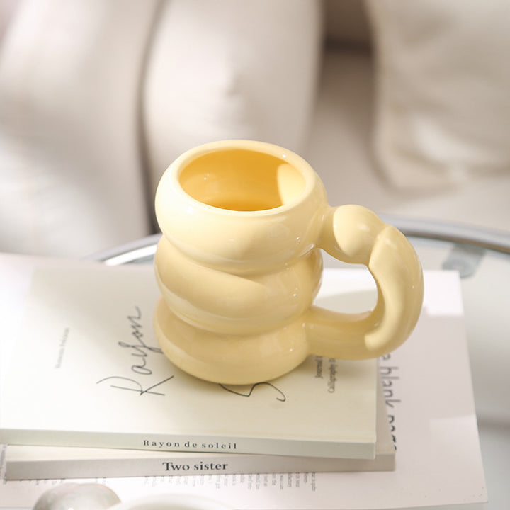 Sculptural ceramic mug with iridescent glaze and curved ring handle