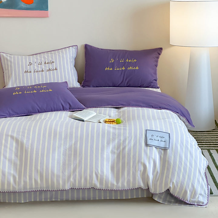Striped cotton bedding set with subtle slogan appliqués and decorative piping