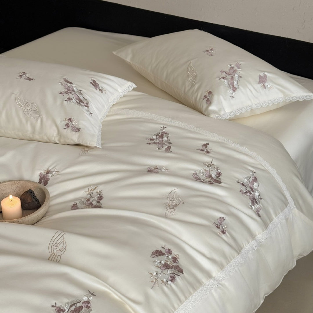 Satin bedding set with subtly embroidered flowers and lace trim