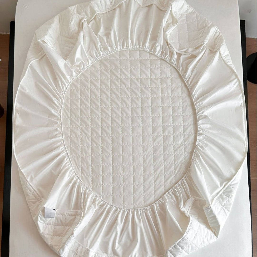 Padded quilted mattress topper with non-slip bottom and breathable fiber filling