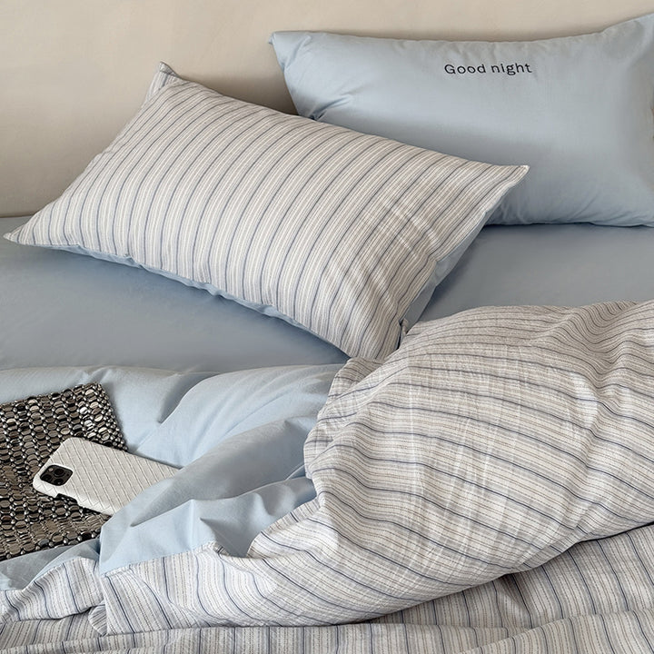 Modern bedding set made of breathable cotton muslin with a fine stripe pattern and reversible function
