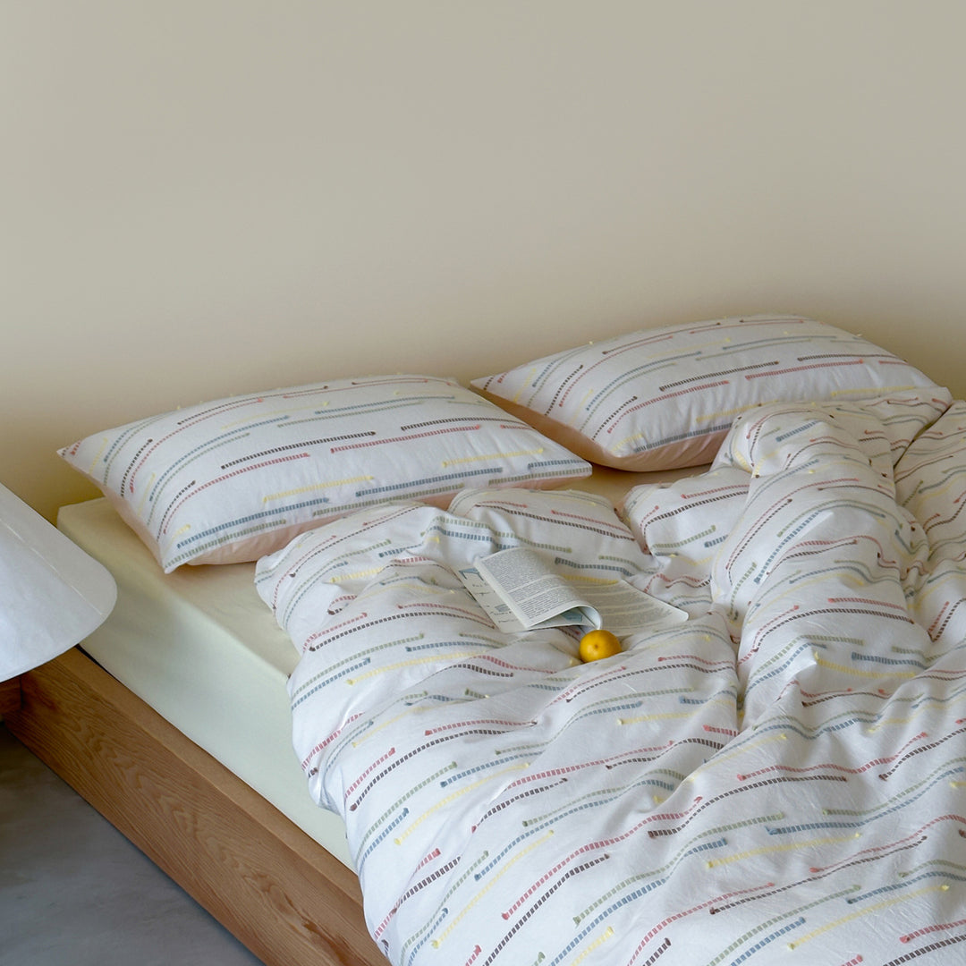 Bedding set made of cotton percale with subtle stripe and pompom design