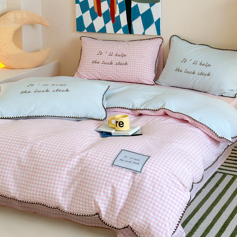Striped cotton bedding set with subtle slogan appliqués and decorative piping