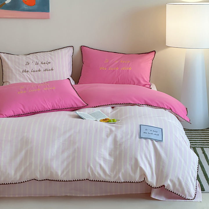 Striped cotton bedding set with subtle slogan appliqués and decorative piping