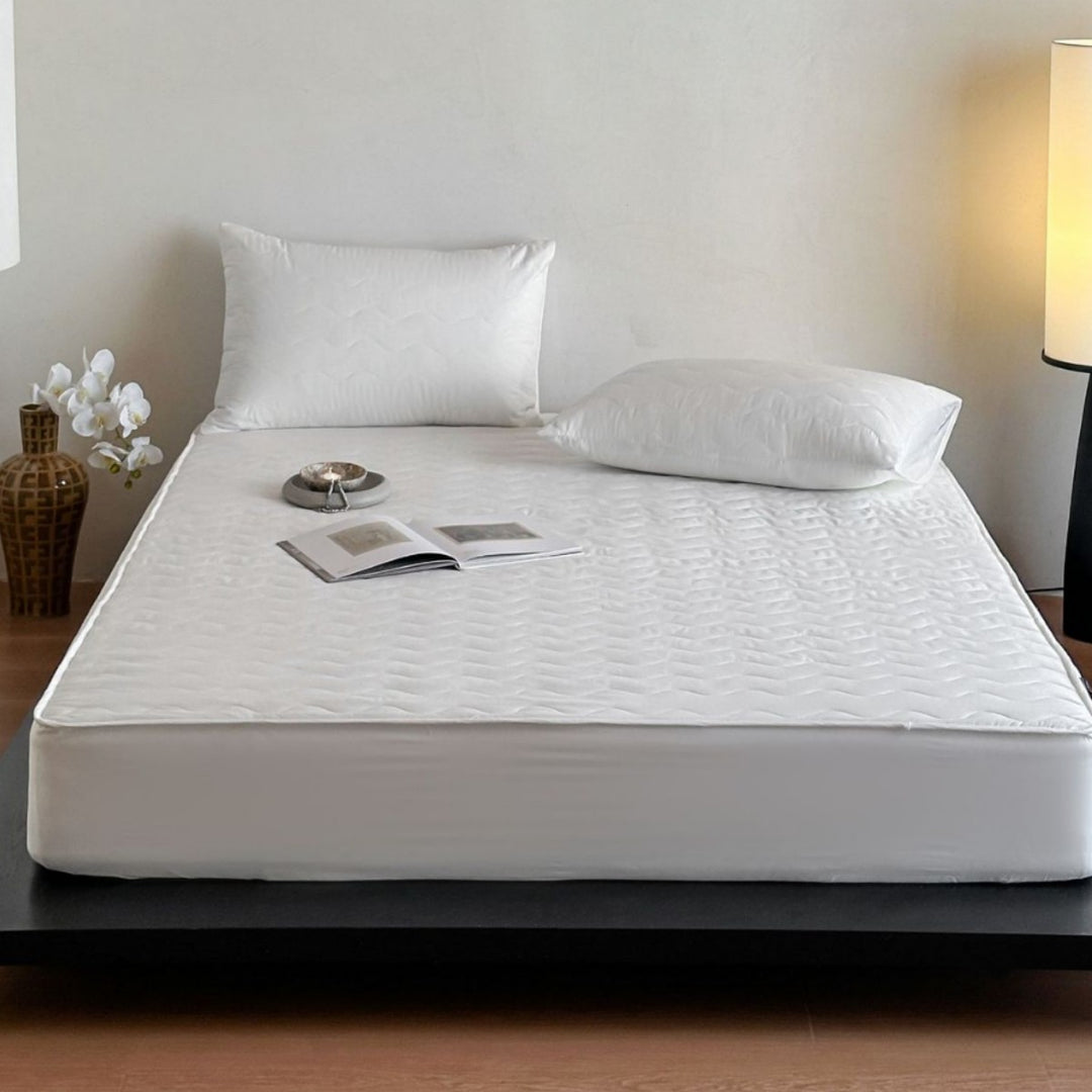Padded mattress protector with all-round stretch and quilting