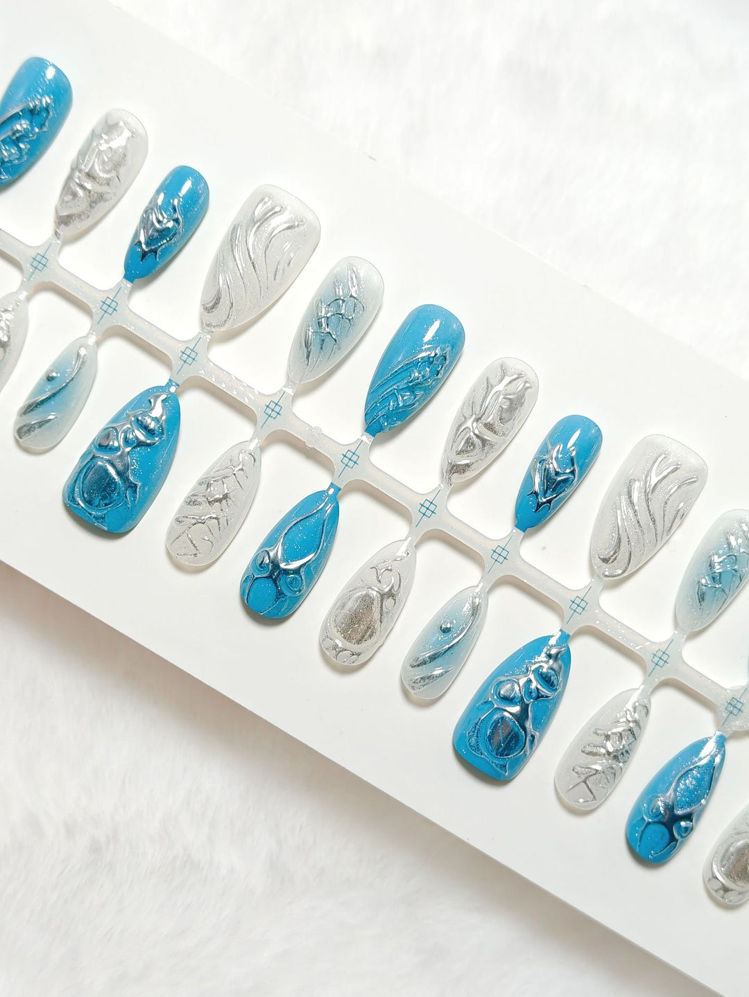 Creative artificial nails with shiny silver and turquoise tones Stornfield
