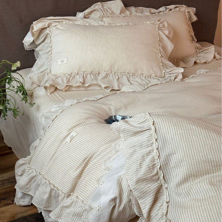 Country house style bed linen set with ruffles, lace border and quilted bedspread