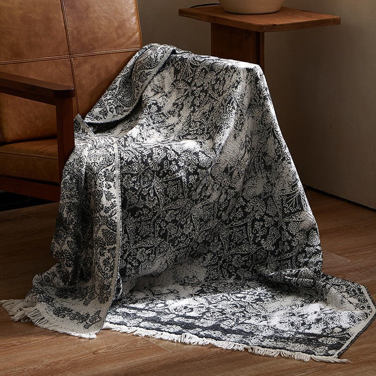 Large cozy living blanket made of cotton blend fabric with geometric jacquard pattern and fringed hem
