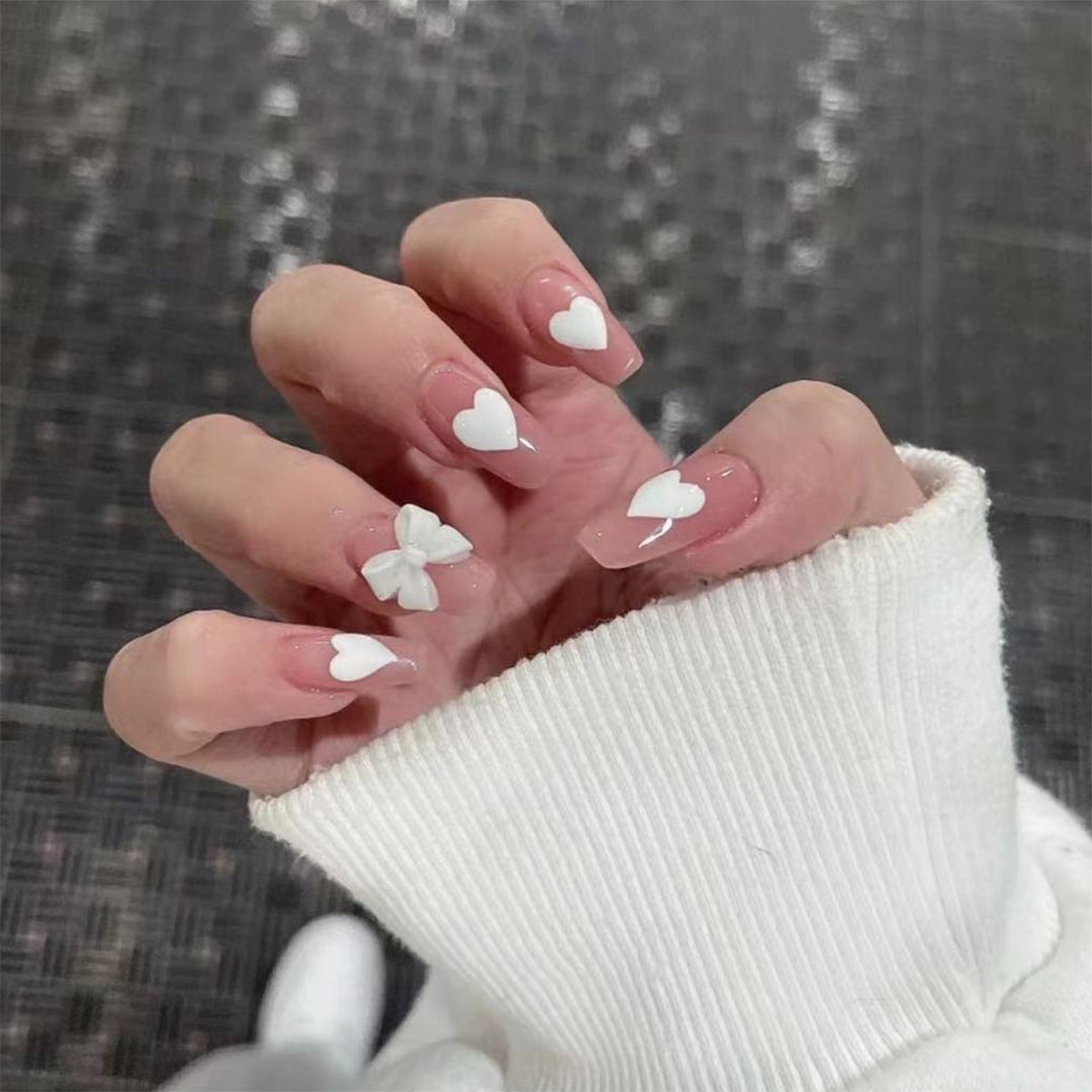 Artistic acrylic nails with heart and bow motifs Stornfield