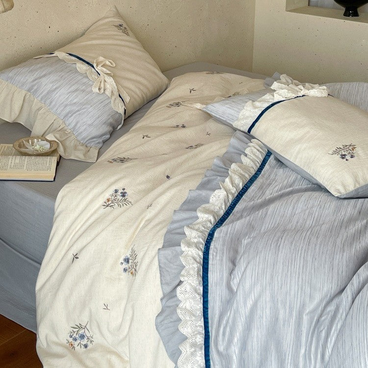 Romantic cotton satin bedding set with ruffles, embroidered flower bouquets, and decorative rolls Stornfield