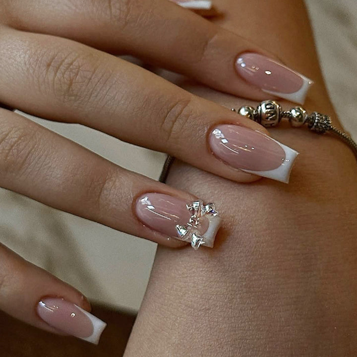 Artificial nail set with luxurious French tips and elegant jewelry embellishments Stornfield