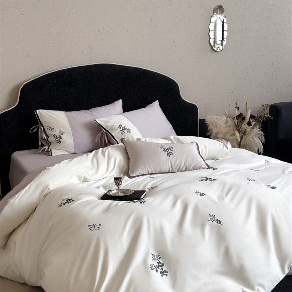Luxurious satin bedding set with embroidered flower pattern and decorative pillow