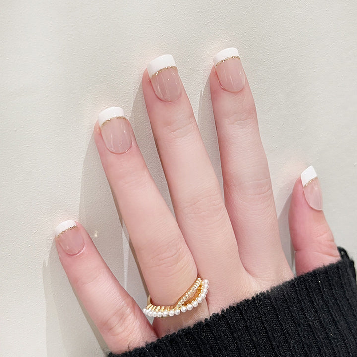 Artful nail extensions with elegant French tip and gold accents Stornfield