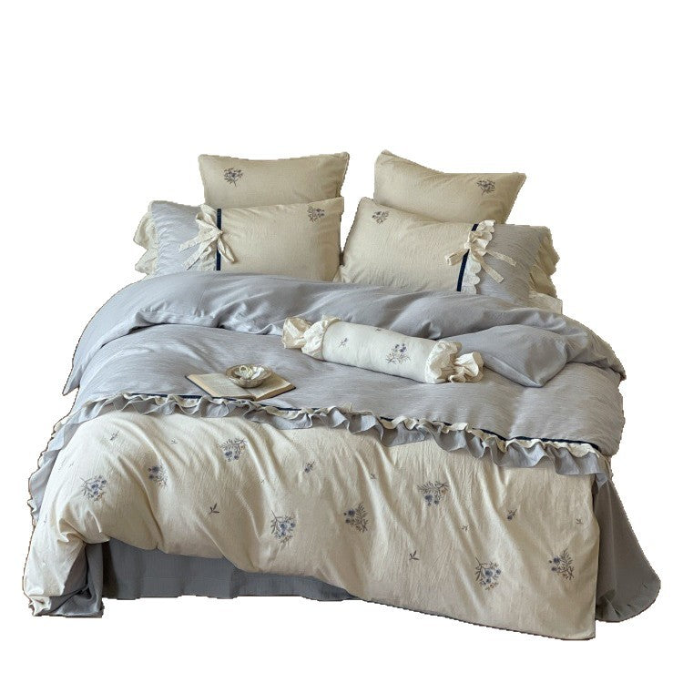 Romantic cotton satin bedding set with ruffles, embroidered flower bouquets, and decorative rolls Stornfield