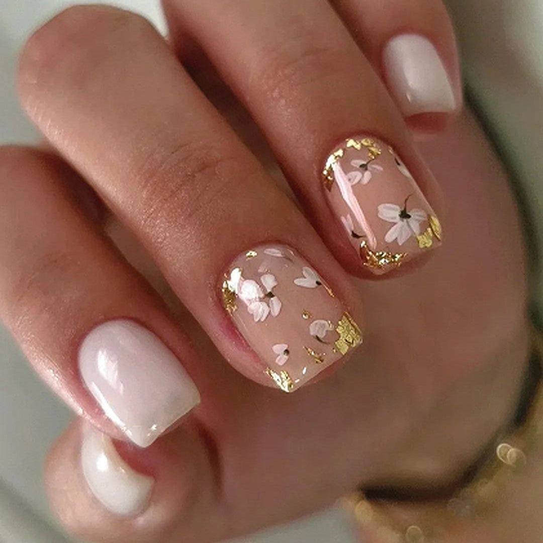 Artificial nail art with delicate flowers and glitter accents Stornfield