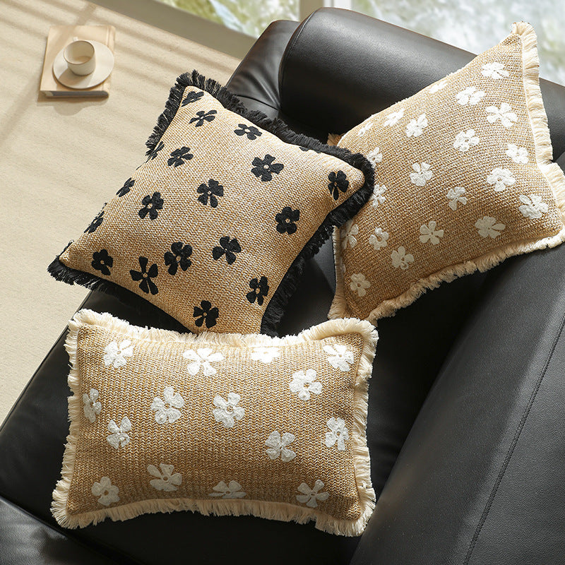 Rectangular woven decorative pillow with contrasting flower tufting and fringe trim