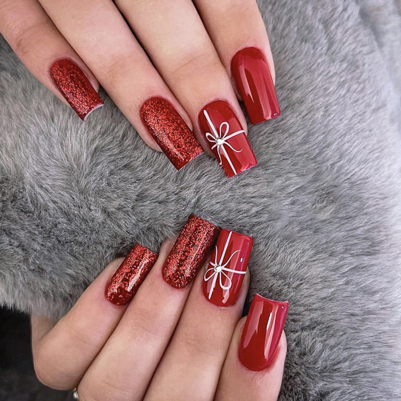Creative acrylic nail set with glitter and bow designs Stornfield