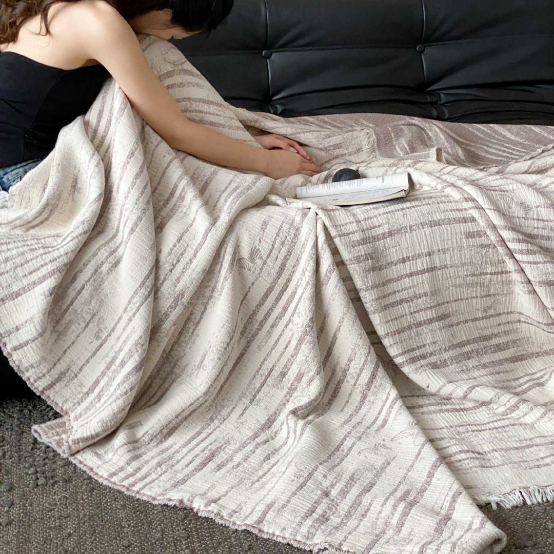 Cozy living blanket made of cotton blend fabric with fringes and striped texture